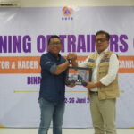 Penyerahan cenderamata oleh Corporate Social Responsibility Manager United Tractors, Himawan Sutanto, kepada Deputy BNPB Pangarso Suryotomo. Foto bersama tim United Tractors dengan perwakilan BNPB, BPBD, dan kader KATANA.