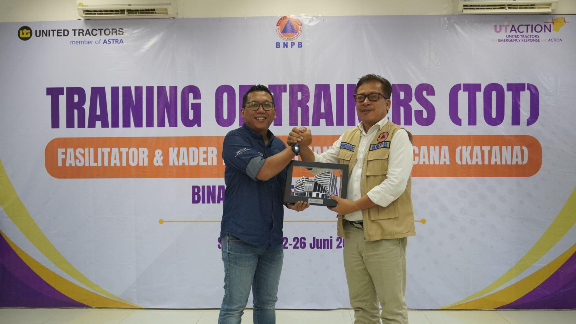 Penyerahan cenderamata oleh Corporate Social Responsibility Manager United Tractors, Himawan Sutanto, kepada Deputy BNPB Pangarso Suryotomo. Foto bersama tim United Tractors dengan perwakilan BNPB, BPBD, dan kader KATANA.